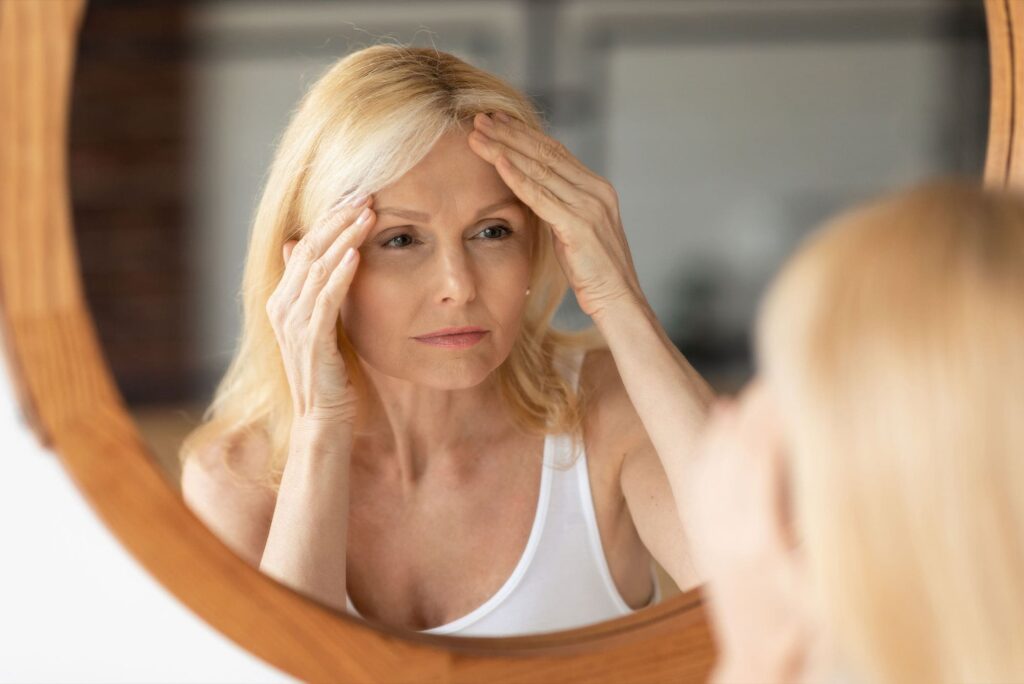 older woman looking in the mirror after getting Botox